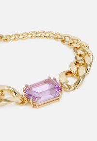 Colier din metal auriu cu lanț, având o piatră prețioasă mare, rectangulară, de culoare violet, într-un montaj sigur, cu un design de verigi lustruite și o textură netedă.
