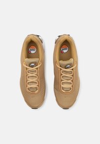 Tan mesh sneakers with a textured upper, round laces, cushioned tan insole, and white rubber sole featuring black accents.