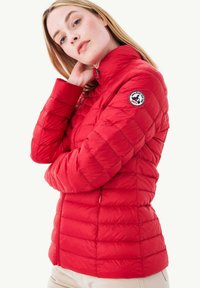 Giacca puffy rossa con motivo trapuntato orizzontale, colletto alto, zip frontale e patch con logo sulla spalla sinistra. Materiale leggero e isolante.