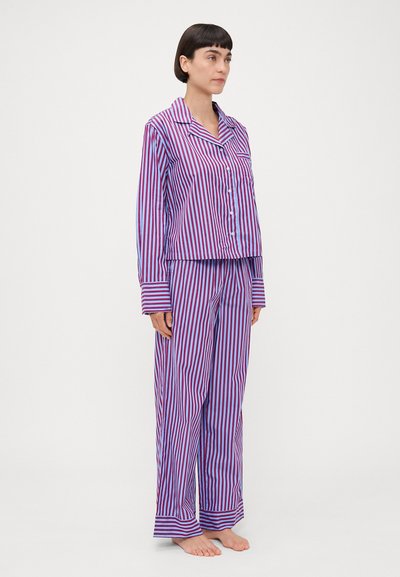 Set de pijama cu dungi în nuanțe de mov și roz, format dintr-o cămașă albă cu guler și butoni și pantaloni lejeri cu manșete largi. Material din bumbac.