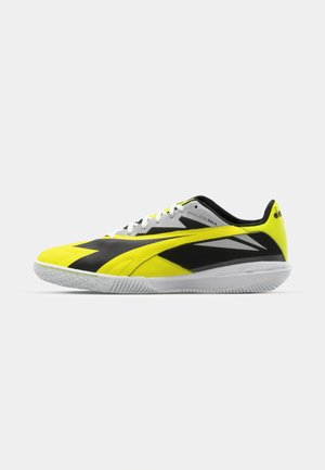 Žuta i crna atletska cipela sa sintetičkim gornjim dijelom, zatvaranjem na vezivanje, teksturiranim potplatom i bijelim akcentima. Pojednostavljen dizajn za vrhunske performanse.