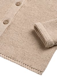 Beige gestrickte Strickjacke mit Holzknöpfen, strukturiertem Gewebe und aufgerolltem Ärmelabschluss, mit einem sauberen Saum und weicher Erscheinung.