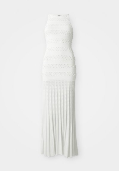 Abito maxi bianco lavorato a maglia con corpino aderente, texture a costine, righe orizzontali e dettagli decorativi a pompom lungo la parte superiore e la gonna.