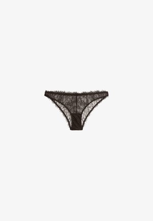 Sous-vêtement féminin style bikini en dentelle noire avec motifs floraux et bords festonnés sur fond blanc.