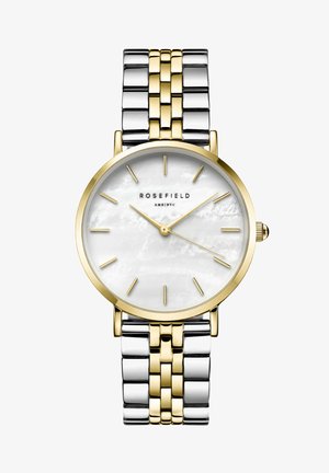 Montre ronde avec un cadran en nacre blanche, index des heures en or et un bracelet en métal bicolore, alliant des maillons en argent brillant et en or.