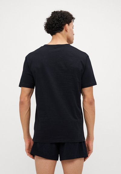 Schwarzes Kurzarm-T-Shirt mit Rundhalsausschnitt und lockerer Passform, hergestellt aus glattem Stoff mit minimaler Textur.