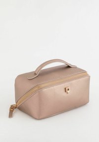 Rektangulær kosmetikpose i lyst beige tekstureret materiale med en guldfarvet lynlås og en lille dekorativ metalpynt på fronten.