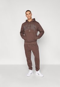 Nike Performance HERITAGE PANT - Trainingsbroek - baroque brown