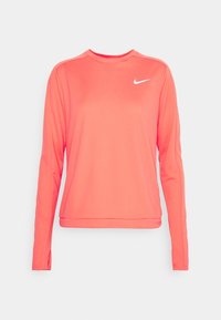 Dlouhý rukáv sportovní tričko v jasně korálové barvě, vyrobené z hladkého, lehkého materiálu. Má kulatý výstřih a malé bílé logo Nike na prsou.