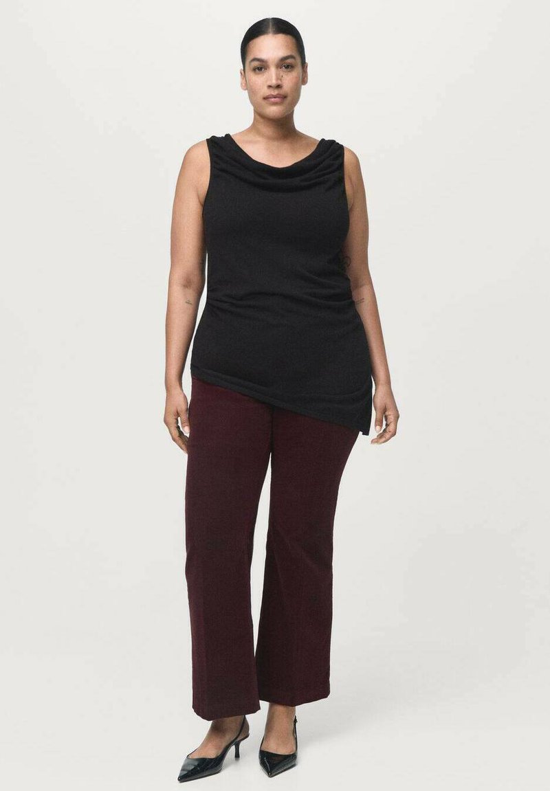 Top negro sin mangas con escote drapeado, combinado con pantalones de pierna amplia burdeos y zapatos de tacón negro. Textura de tela suave.