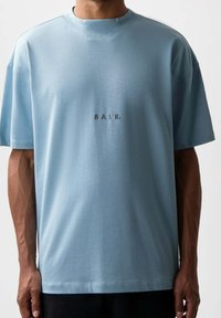 Hellblaues T-Shirt mit kurzen Ärmeln aus weichem Stoff, mit Rundhalsausschnitt und kleinem aufgesticktem Logo "BALR." auf der Brust.