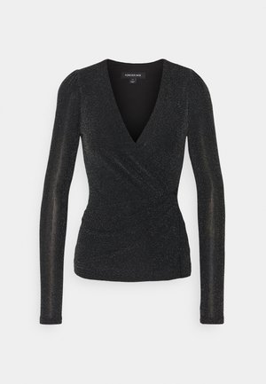 Zwarte wikkel-top met lange mouwen, subtiele glittertextuur en een diepe V-hals.