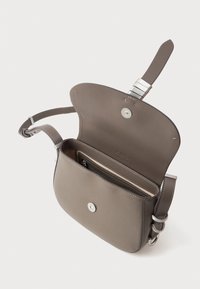 Borsa a tracolla in pelle grigia con una patta curvata, hardware in argento e un interno suddiviso con un compartimento con zip. Cinghia regolabile.