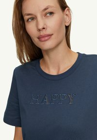 Dunkelblaue Baumwoll-T-Shirt mit gesticktem Text "HAPPY" in verschiedenen Farben und Texturen. Runder Ausschnitt und kurze Ärmel.
