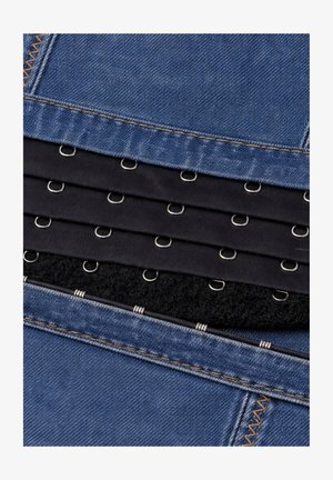 Primer plano de tela vaquera en capas con tiras de tela negra que presentan cierres de gancho y ojo de metal alineados en filas.