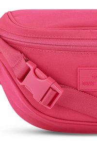 Rózsaszín, sima textúrájú vászonválltáska, műanyag csattal és márkás címkével. Cipzáras zárás a tetején.