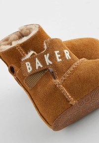Smeđe suede čizme za todlere s mekanim krznom iznutra, s bijelim šivanim oznakom "BAKER" i teksturiranim gumiranim potplatom.