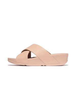 Beige slipper met gekruiste bandjes over de voet en een lage sleehak, ontworpen voor casual gebruik.
