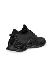 Black athletic shoe featuring a breathable mesh upper, textured detailing, and a molded rubber sole with distinctive wave-like design.