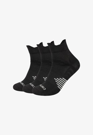 Tre paia di calzini neri alla caviglia con texture a coste e logo bianco del marchio vicino alle dita, disposti sovrapposti su sfondo bianco.