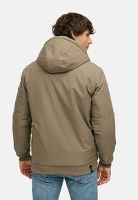 Giacca puffer khaki con cappuccio, polsini e orlo a coste. Presenta un tessuto liscio con finitura opaca e tasche laterali.