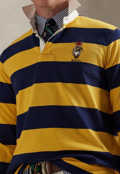 Κίτρινη και ναυτική ριγέ ράγκμπι μπλούζα με λευκό γιακά, που διαθέτει κεντημένο λογότυπο αρκούδας και κλασικό σχεδιασμό με κουμπότρυπες.