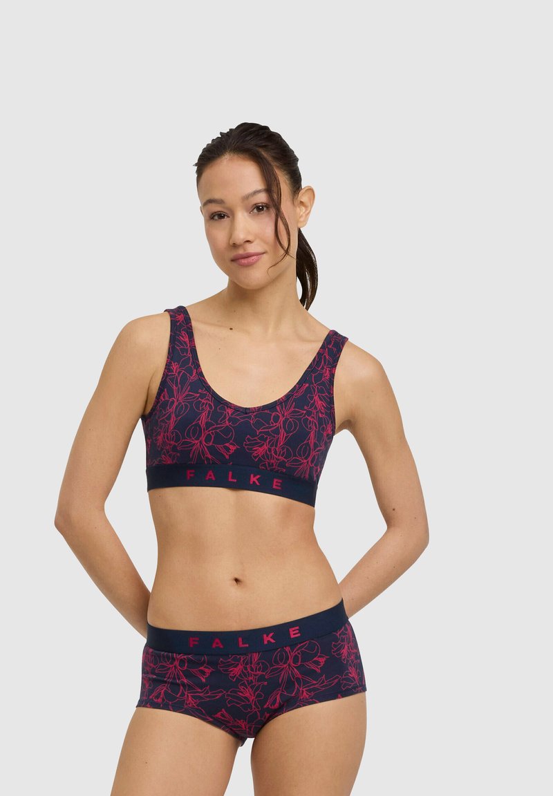 Granatowy zestaw sportowy: biustonosz i szorty z różowym kwiatowym wzorem. Miękka tkanina, szerokie ramiączka oraz elastyczna opaska z logo "FALKE".