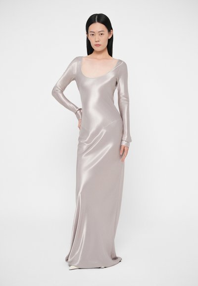 Saténové šaty s dlhými rukávmi, výstrihom do oblúka, v jemnej striebornej farbe. Silueta priliehajúca na telo, dĺžka po zem, hladká textúra.