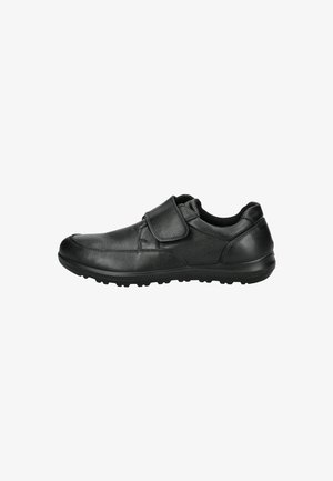 Chaussure en cuir noir avec une sangle velcro, bout rond, dessus texturé et semelle en caoutchouc avec de petits motifs de crampons.