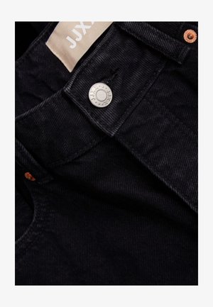 Μαύρο τζιν παντελόνι με απαλό υφή, διαθέτει μεταλλικό κούμπωμα σε ασημί απόχρωση, χάλκινες βελόνες και ετικέτα από ύφασμα με την επωνυμία "JJX".