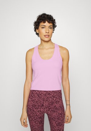 Top de alças sem mangas rosa com decote redondo, combinado com leggings de cintura alta com padrão de animal em rosa escuro e preto.
