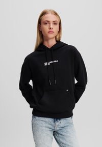 Svart hoodie i bomull med en framficka, dragsko på huvan och vit "Karl Lagerfeld Jeans"-logotyp på bröstet.