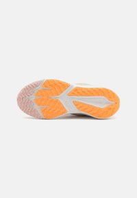 Semelle de chaussure Nike présentant un motif ondulé et texturé en orange et rose, avec une section gris uni. Semelle conçue pour l'adhérence et le soutien.