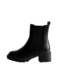 Czarny botek sięgający do kostki, wykonany z gładkiej skóry, z elastycznymi bocznymi panelami, niskim obcasem oraz białym przeszyciem wzdłuż podeszwy.