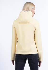 Jachetă galbenă impermeabilă cu glugă, textură netedă, mâneci lungi și un design ajustat. Cusături vizibile și detaliu cu glugă strânsă.