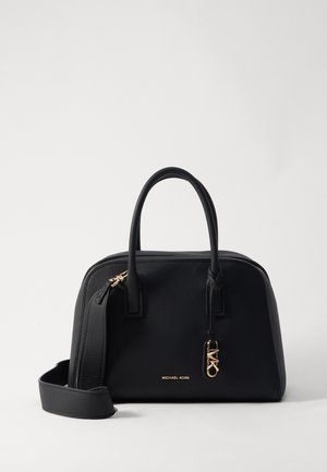 Zwarte Michael Kors handtas met dubbele handvatten, gouden MK-logohanger en een afneembare schouderriem op een effen witte achtergrond.