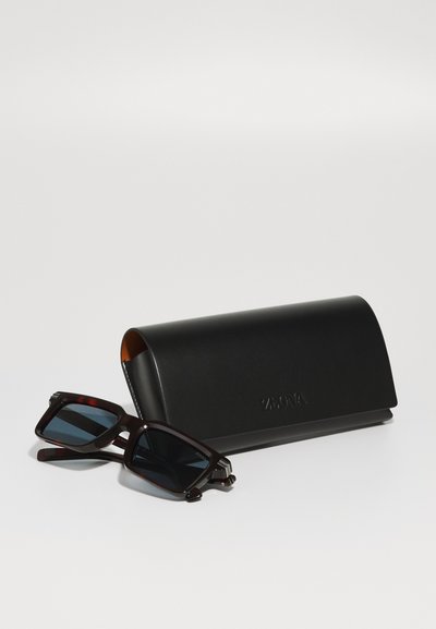 Sunglasses with dark lenses in a rectangular brown tortoiseshell frame, accompanied by a sleek black leather case featuring embossed branding.