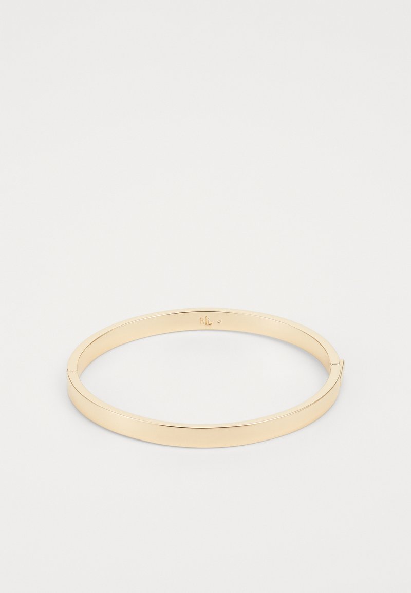 Gold metal bangle with a smooth, polished finish. Features a sleek, circular design with a slight opening for wearing.