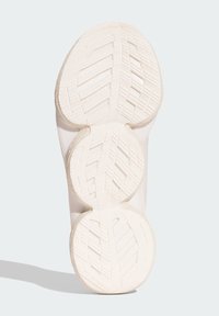 Semelle de chaussure de sport blanche avec un motif texturé, des courbes lisses et deux sections arrondies pour l'adhérence. Présente des rainures de flexibilité pour un meilleur confort.