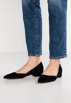 Czarne zamszowe baleriny z ostrymi noskami i niskim, blokowym obcasem. Projekt obejmuje wycięcie po boku dla nowoczesnego wyglądu, stylizowane z niebieskimi dżinsami.