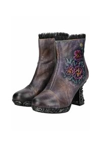 Botas de tobillo de cuero morado y marrón con grabado floral, un borde de encaje negro texturizado y un tacón alto negro ornamentado.