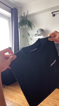 Fekete póló kerek nyakkal és rövid ujjal. A bal mellen egy kis "PEGADOR" logó található. Simaság jellemzi a szövet textúráját.