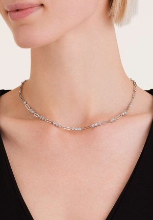 Zilveren ketting met afwisselend ovale en diamanten schakels, versierd met kleine decoratieve accenten, om de nek gedragen.