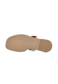 Sandalen met een beige rubberen zool, met een gladde textuur en minimale uitstraling, en een witte bovenkant met een sluiting als accent.