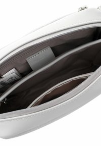 Weiße synthetische Tasche mit Reißverschluss, die ein geräumiges Innenfach, mehrere Fächer und eine glatte Textur bietet.