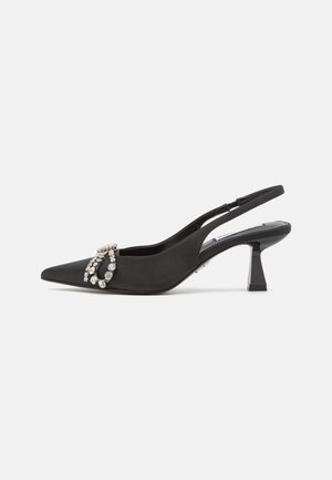 Schwarze Satin-Slingback-Kitten-Heels mit spitzem Zehenbereich und Strassschnalle auf der Vorderseite, isoliert auf weißem Hintergrund.