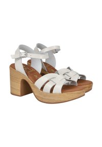 Sandalias de plataforma de cuero blanco con correas entrelazadas, tacón de madera, correa de tobillo ajustable y plantilla marrón. Superficie texturizada.