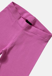 Leggings di cotone rosa con una superficie liscia, dotati di una vita elasticizzata e cuciture piatte per comfort e libertà di movimento.
