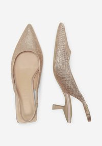 Scarpe slingback impreziosite da strass in nude, con punta affusolata e un tacco basso e squadrato, dotate di una fodera interna liscia e di un retro aperto.