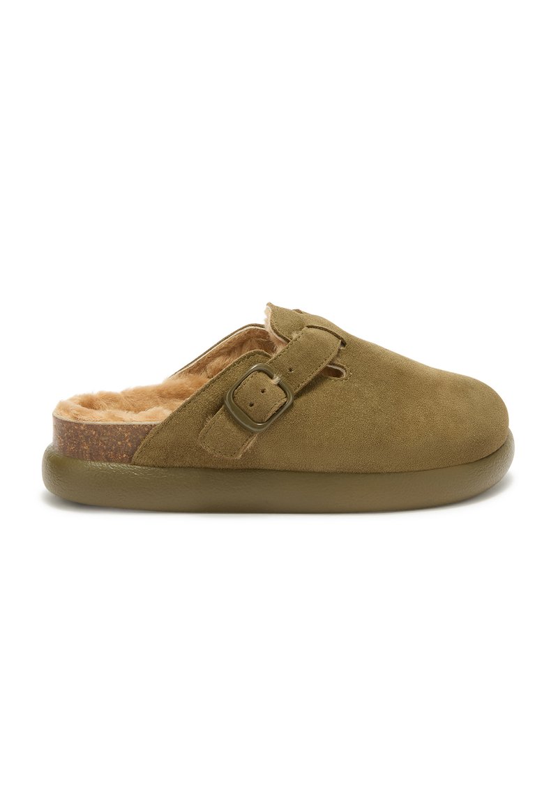 Olive green suede slip-on shoe with a plush tan interior, flat olive sole, and a side buckle for adjustable fit.